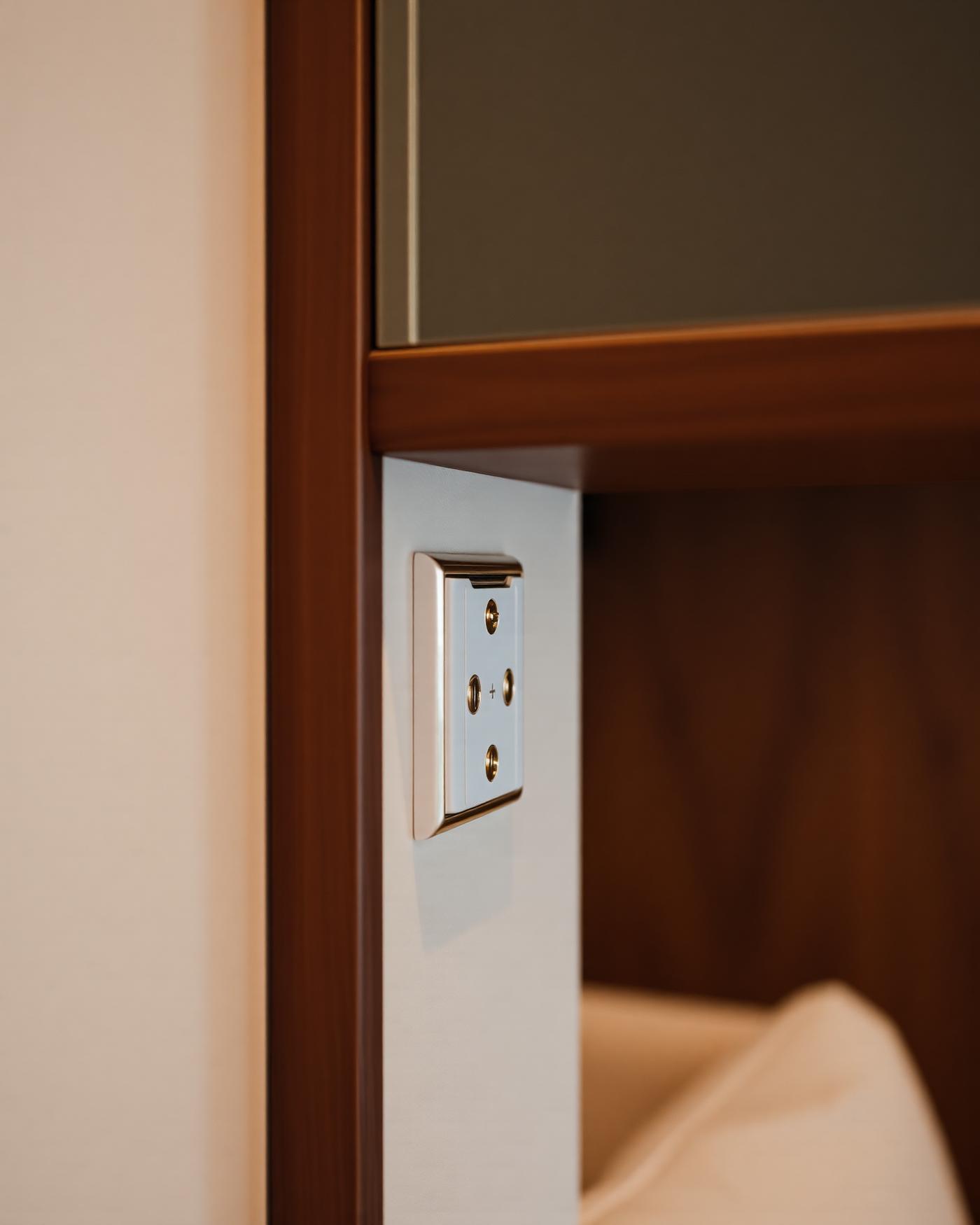 Brass keypad detail beside walnut joinery